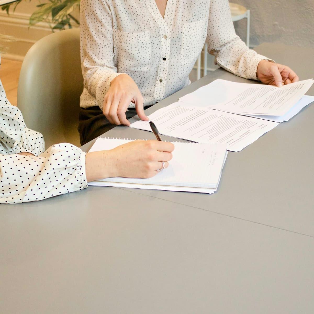 An adviser and a client going through documents together at a desk